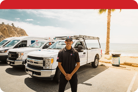 a man standing in front of work trucks on a beach