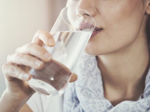 Young woman drinking pure glass of water
