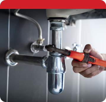Plumber fixing sink drain with wrench